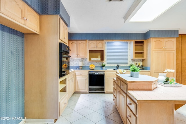 kitchen with tile counters, a center island, light brown cabinetry, light tile patterned floors, and black appliances