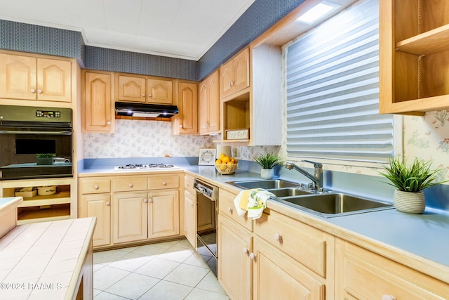 kitchen featuring sink, light tile patterned floors, light brown cabinets, and black appliances