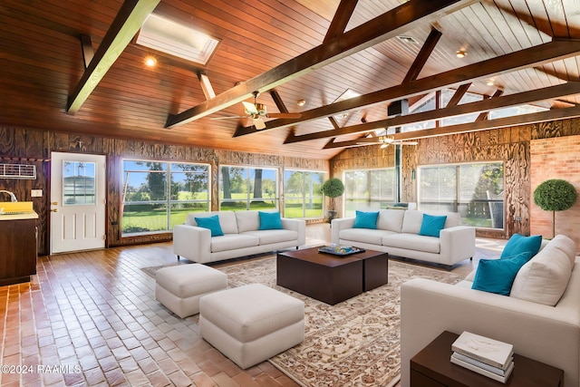 sunroom / solarium featuring lofted ceiling with skylight, sink, ceiling fan, and a healthy amount of sunlight