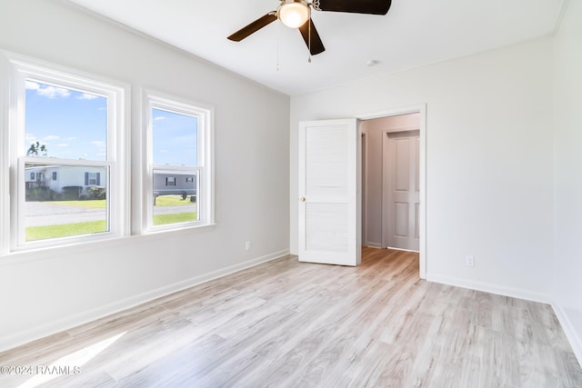 spare room with light wood-type flooring and ceiling fan