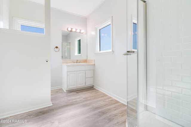 bathroom featuring a shower, vanity, and hardwood / wood-style flooring