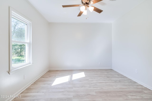 empty room with light hardwood / wood-style flooring, ceiling fan, and a healthy amount of sunlight