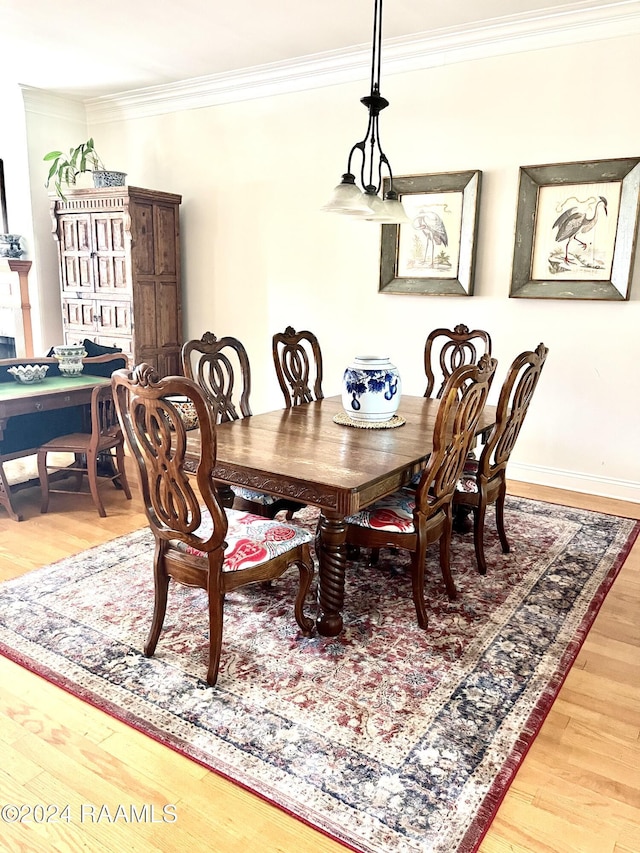 dining space featuring hardwood / wood-style flooring and crown molding