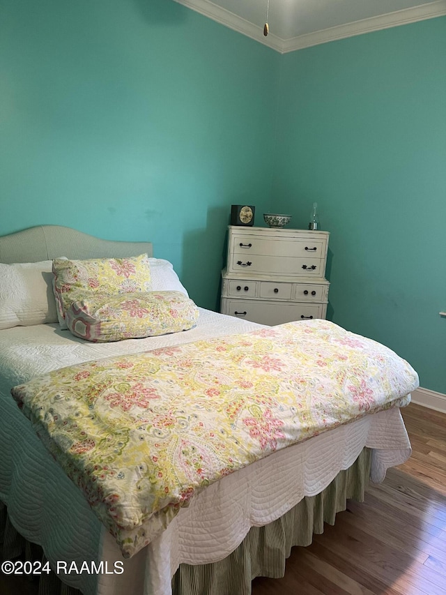 bedroom with crown molding and hardwood / wood-style floors