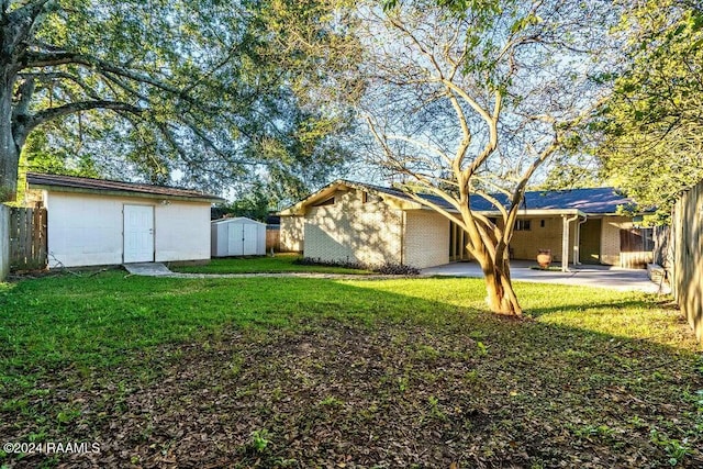 view of yard with a shed and a patio area