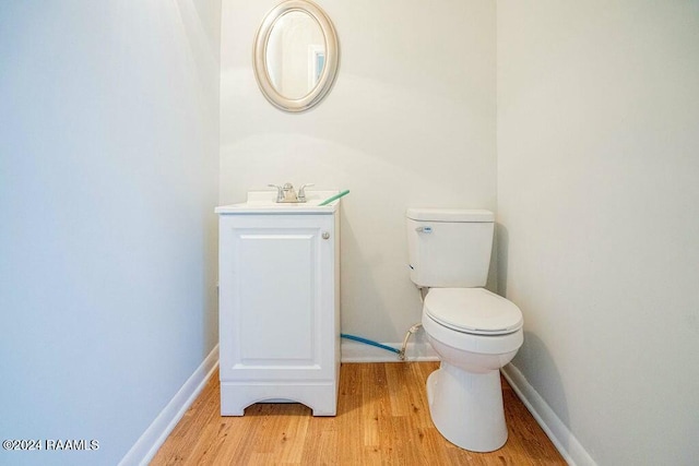 bathroom with vanity, toilet, and wood-type flooring