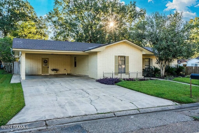 single story home featuring a carport and a front lawn