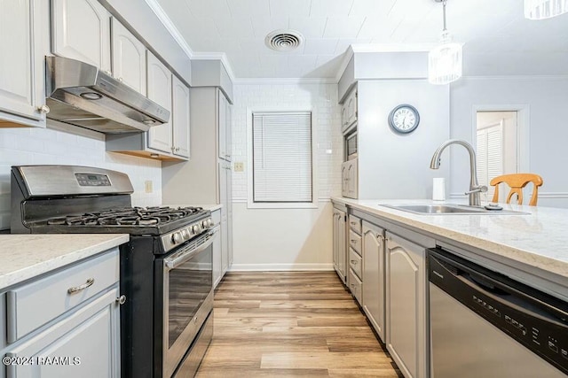 kitchen featuring stainless steel appliances, crown molding, sink, light hardwood / wood-style floors, and hanging light fixtures