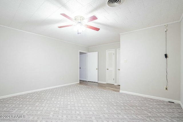 spare room with carpet flooring, ceiling fan, and crown molding