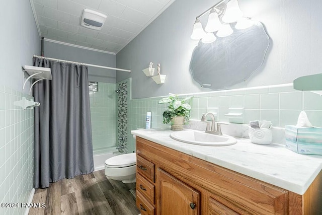 full bathroom featuring toilet, hardwood / wood-style flooring, vanity, tile walls, and ornamental molding