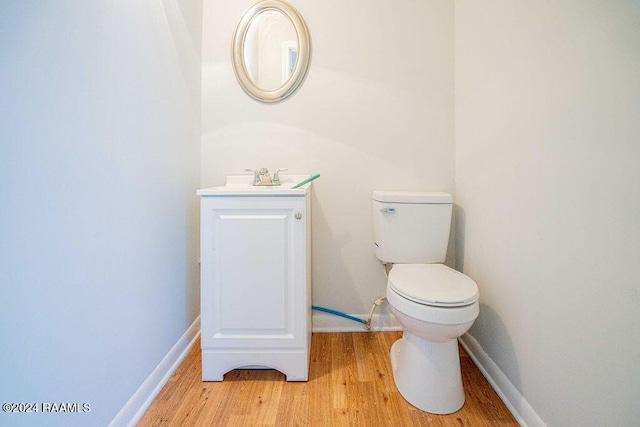 bathroom with hardwood / wood-style floors, vanity, and toilet