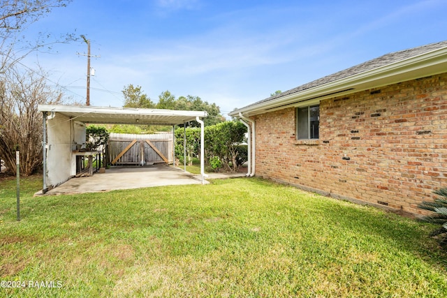 227 Meadow Ln, Lafayette, LA 70506 - view of green lawn featuring a gate, a carport, and a patio area
