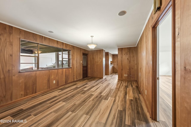 spare room with wooden walls, ornamental molding, and hardwood / wood-style flooring