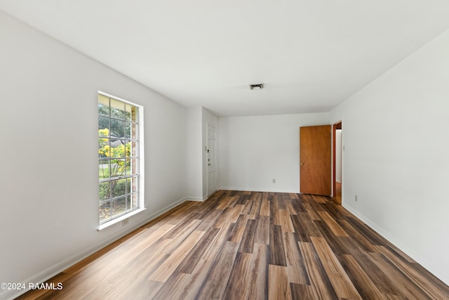 spare room featuring dark hardwood / wood-style floors and plenty of natural light