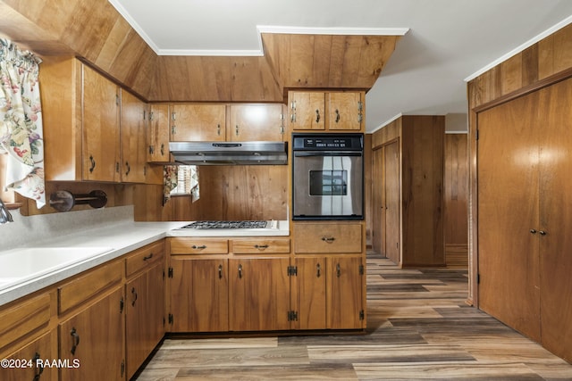 kitchen featuring dark hardwood / wood-style floors, ornamental molding, sink, and appliances with stainless steel finishes