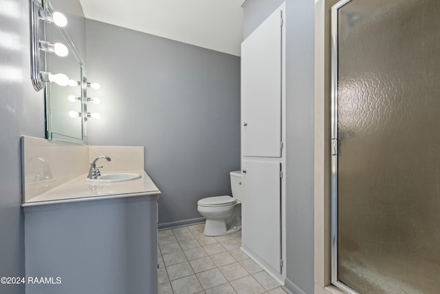 bathroom with toilet, vanity, tile patterned floors, and a shower with shower door