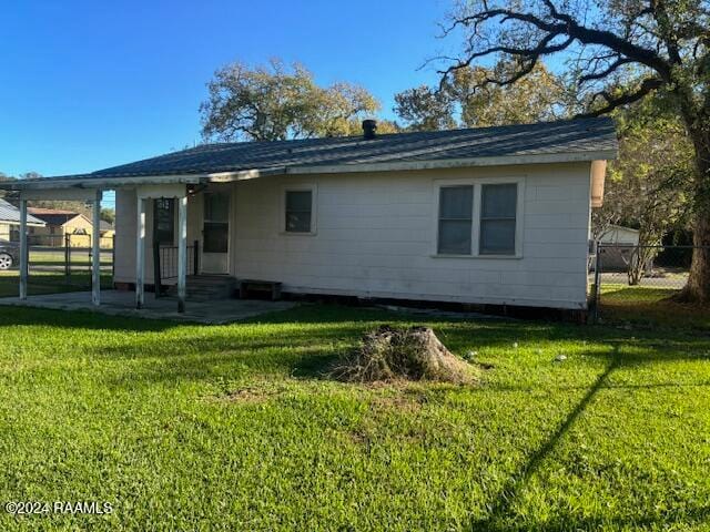 back of house featuring a lawn