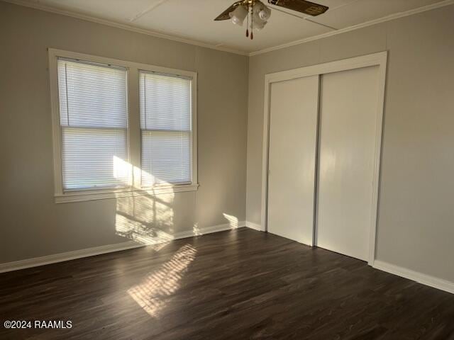 unfurnished bedroom featuring ceiling fan, dark hardwood / wood-style flooring, multiple windows, and a closet