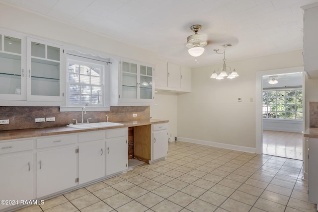 kitchen with decorative light fixtures, white cabinetry, a healthy amount of sunlight, and sink