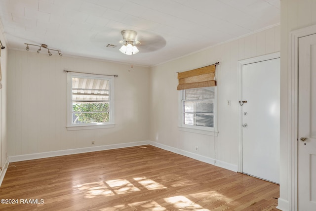 spare room with crown molding, ceiling fan, and light hardwood / wood-style floors