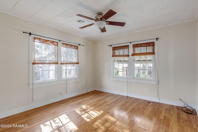 spare room featuring ceiling fan, crown molding, and light wood-type flooring