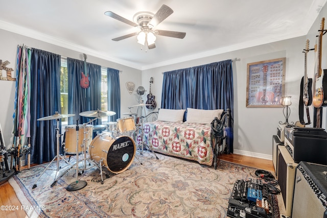 bedroom with ceiling fan, crown molding, and wood-type flooring