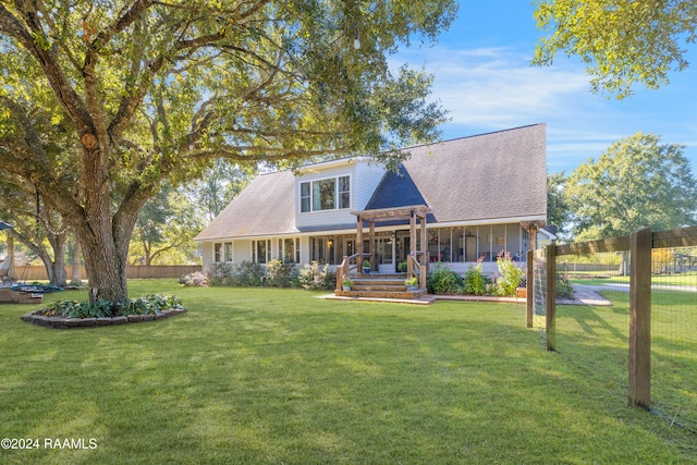 new england style home with a sunroom and a front lawn