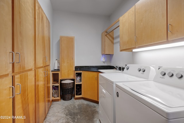 washroom with cabinets, tile patterned flooring, washer and clothes dryer, and sink