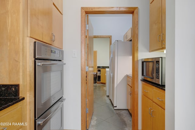 kitchen featuring light brown cabinets, light tile patterned floors, and stainless steel appliances