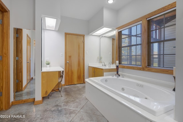 bathroom with tile patterned floors, a tub, and vanity