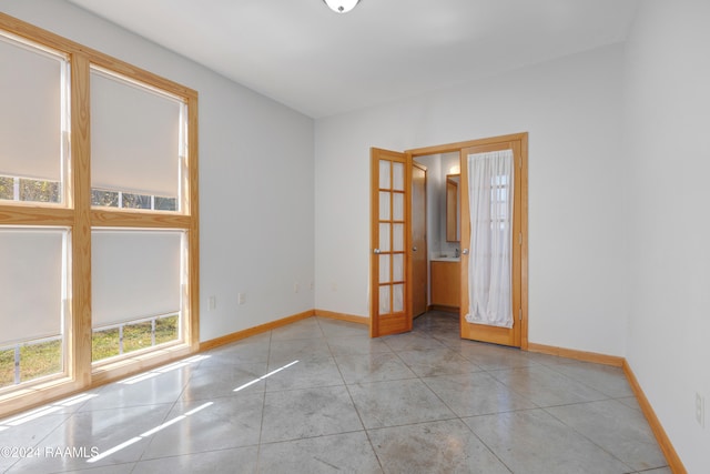 unfurnished room with french doors and light tile patterned floors