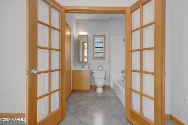 bathroom with tile patterned flooring, vanity, toilet, and french doors