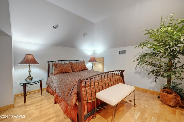 bedroom with light wood-type flooring and lofted ceiling