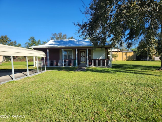 view of front of house with a front lawn, covered porch, and a carport