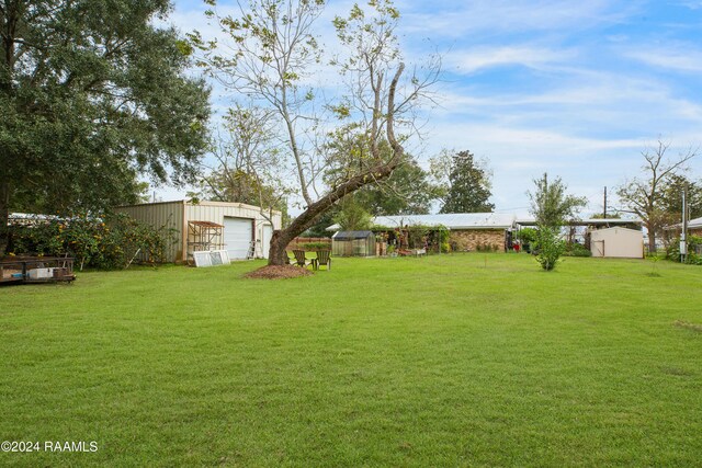 view of yard featuring a garage and an outdoor structure