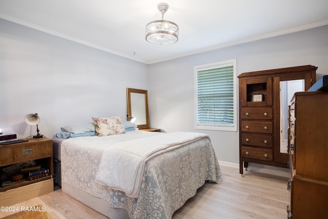 bedroom featuring light wood-type flooring and ornamental molding