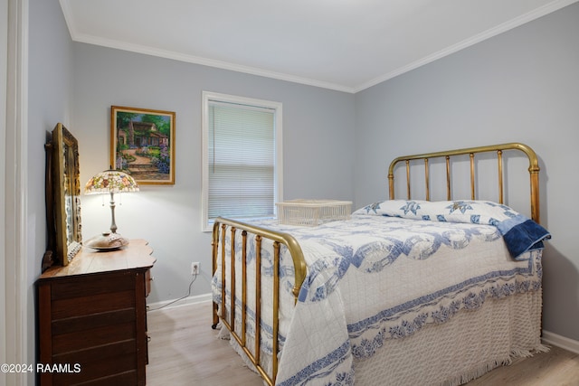 bedroom with light hardwood / wood-style floors and ornamental molding