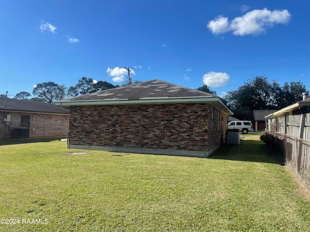 exterior space featuring a yard and central AC