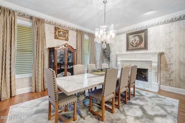 dining space with hardwood / wood-style flooring, ornamental molding, and a chandelier