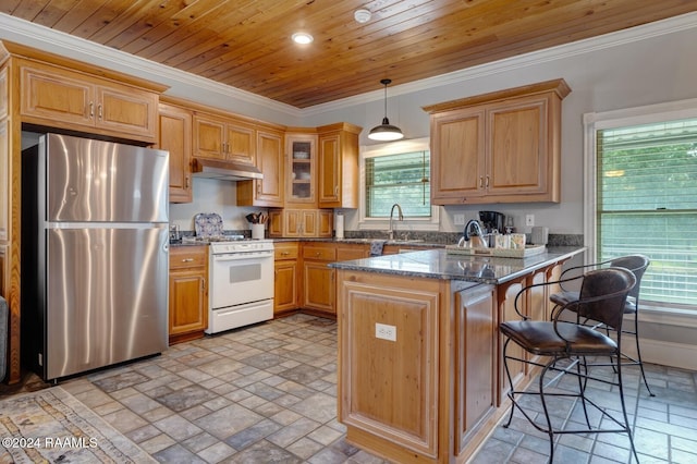 kitchen featuring white stove, hanging light fixtures, dark stone countertops, kitchen peninsula, and stainless steel refrigerator