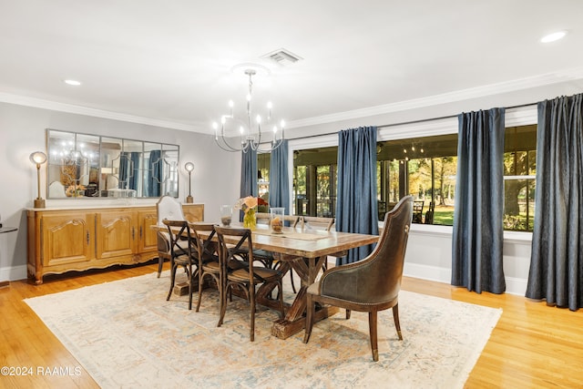 dining area featuring an inviting chandelier, ornamental molding, and light hardwood / wood-style flooring