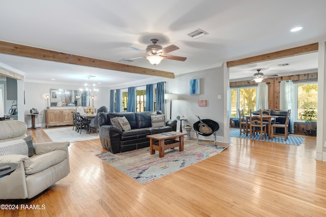 living room with beamed ceiling, ceiling fan with notable chandelier, light hardwood / wood-style flooring, and ornamental molding