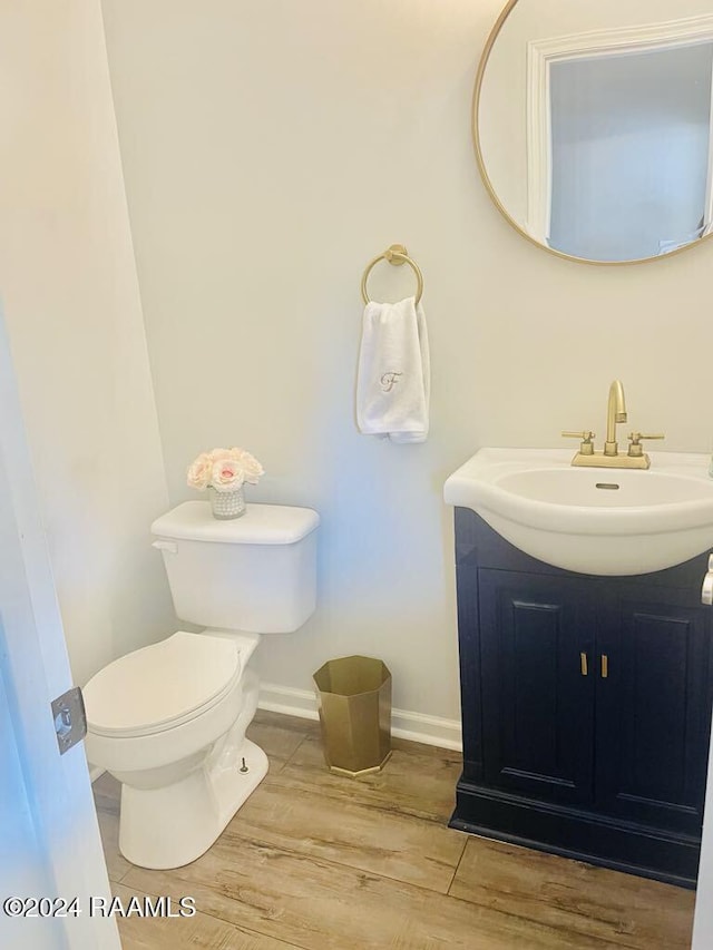 bathroom featuring vanity, hardwood / wood-style flooring, and toilet