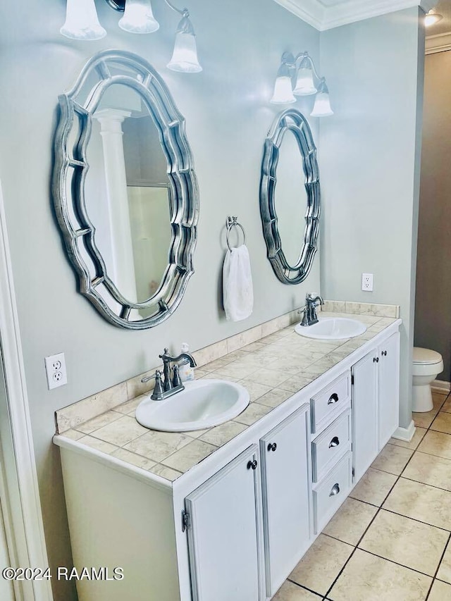 bathroom featuring tile patterned floors, crown molding, vanity, and toilet