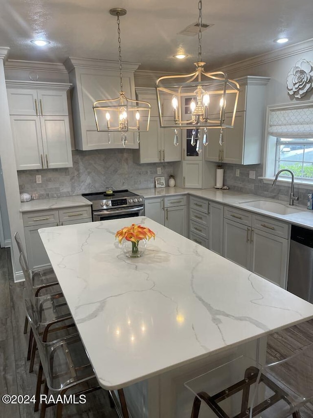 kitchen featuring a spacious island, sink, electric range, light stone countertops, and a breakfast bar area