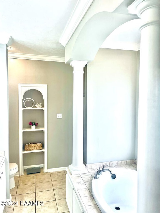 bathroom featuring a bathing tub, tile patterned floors, toilet, ornate columns, and ornamental molding