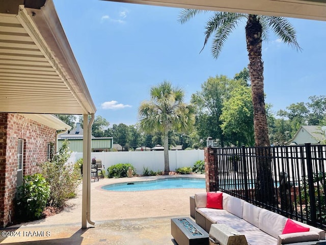 view of pool with a patio area and an outdoor living space with a fire pit