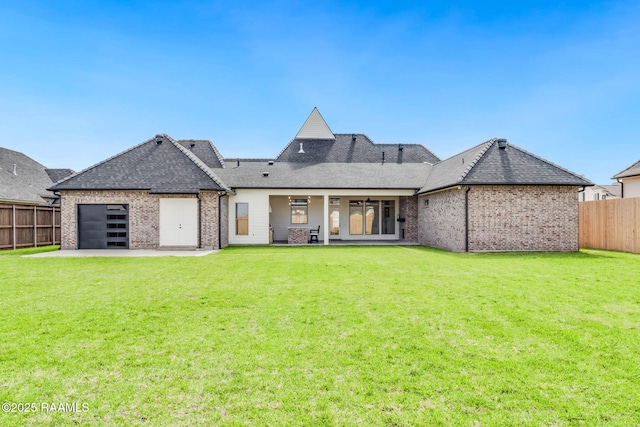 back of house featuring brick siding, a fenced backyard, a garage, a shingled roof, and a lawn
