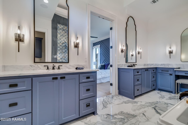 ensuite bathroom with two vanities, ensuite bath, marble finish floor, and a sink