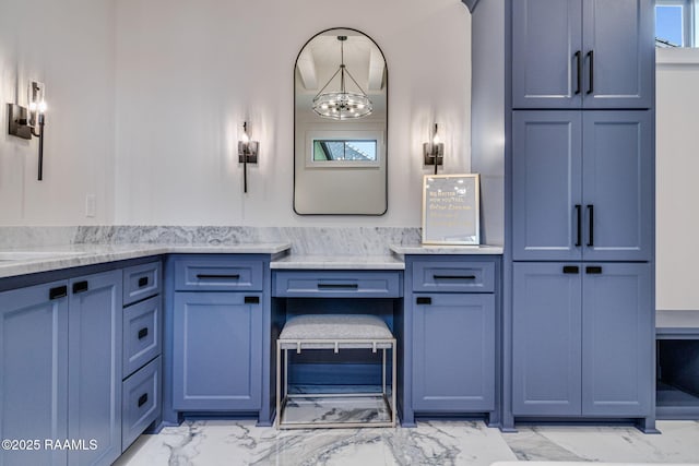 bathroom featuring vanity, marble finish floor, and an inviting chandelier
